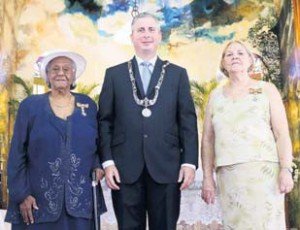 New members in the Order of Orange-Nassau, Carmen Simmons (left) and Patricia Johnson with Island Governor Jonathan Johnson.