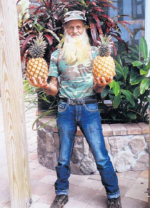 Richard “Tarzan” Hassell showing his “record” pineapples.