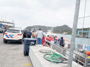 Murder suspect (second right) disembarks MV Waterman in St. Eustatius.
