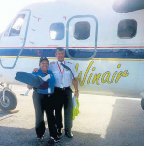 From left: Domino’s representative Shonella Puran and Winair Captain Frederic Rochemont with pizza in front of a Winair plane.