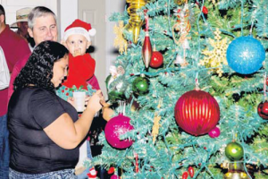 Island Governor Jonathan Johnson and his daughter Mia, admiring the Christmas tree at Eugenius A. Johnson Centre.